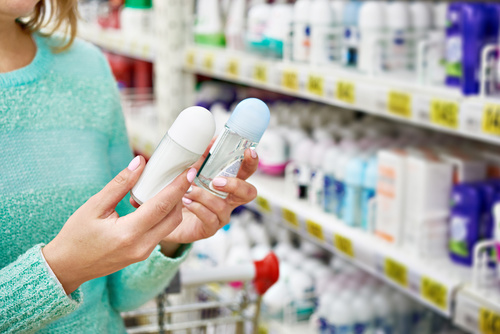 Woman choosing between deodorants to treat excessive underarm sweating