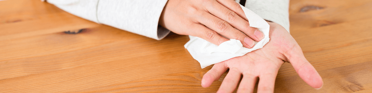 Using wipe to clean sweaty hand with palmar hyperhidrosis